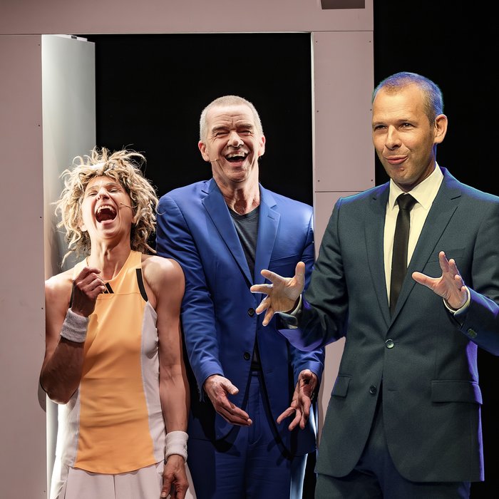 Ursus, Nadeschkin und Helge Thun in einem Bühnenbild. Die beiden links, Ursus und Nadeschkin, lachen, Helge Thun rechts scheint regade zu sprechen und gestikuliert mit seinen Händen.