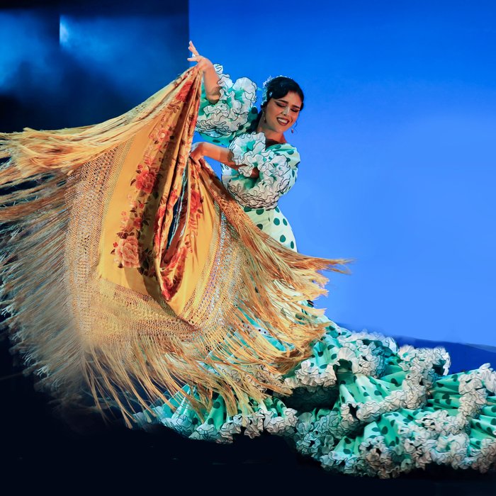 Tänzerin in aufwändig gestaltetem Flamenco Kleid auf der Bühne
