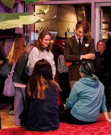 Junge Menschen sind stehend und sitzend im Gespräch im Theaterhaus