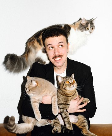 Fred Costea mit drei Katzen auf dem Arm