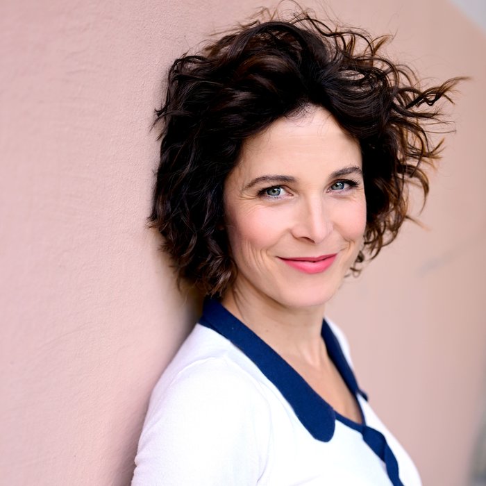 Portraitfoto von Katalyn Hühnerfeld, sie lehnt an einer Wand