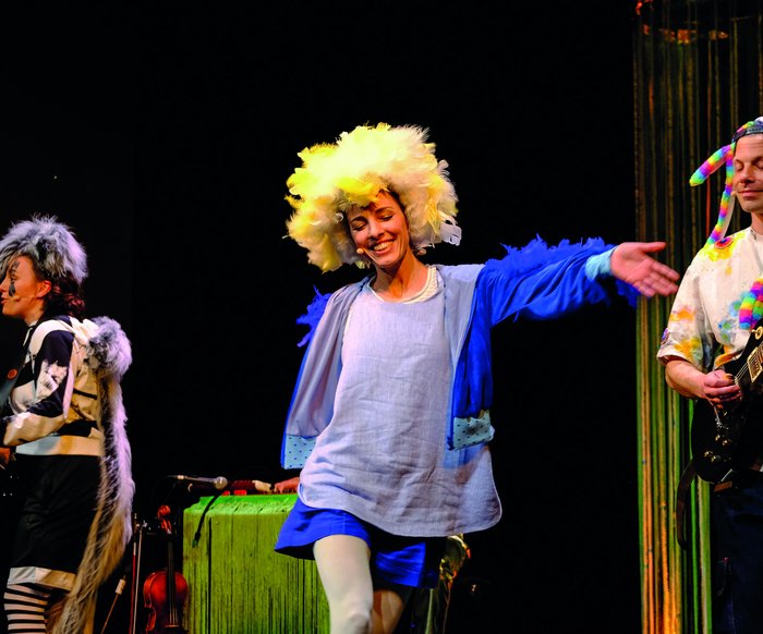 Eine Person, die auf der Bühne als Eule verkleidet ist, tanzt