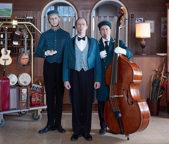 Drei Männer mit Instrumenten in einem Hotel