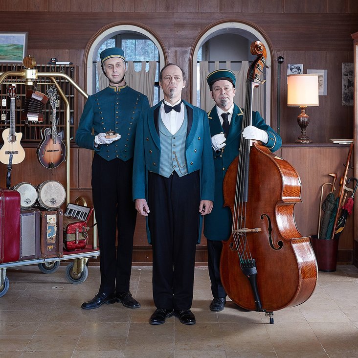 Drei Männer mit Instrumenten in einem Hotel